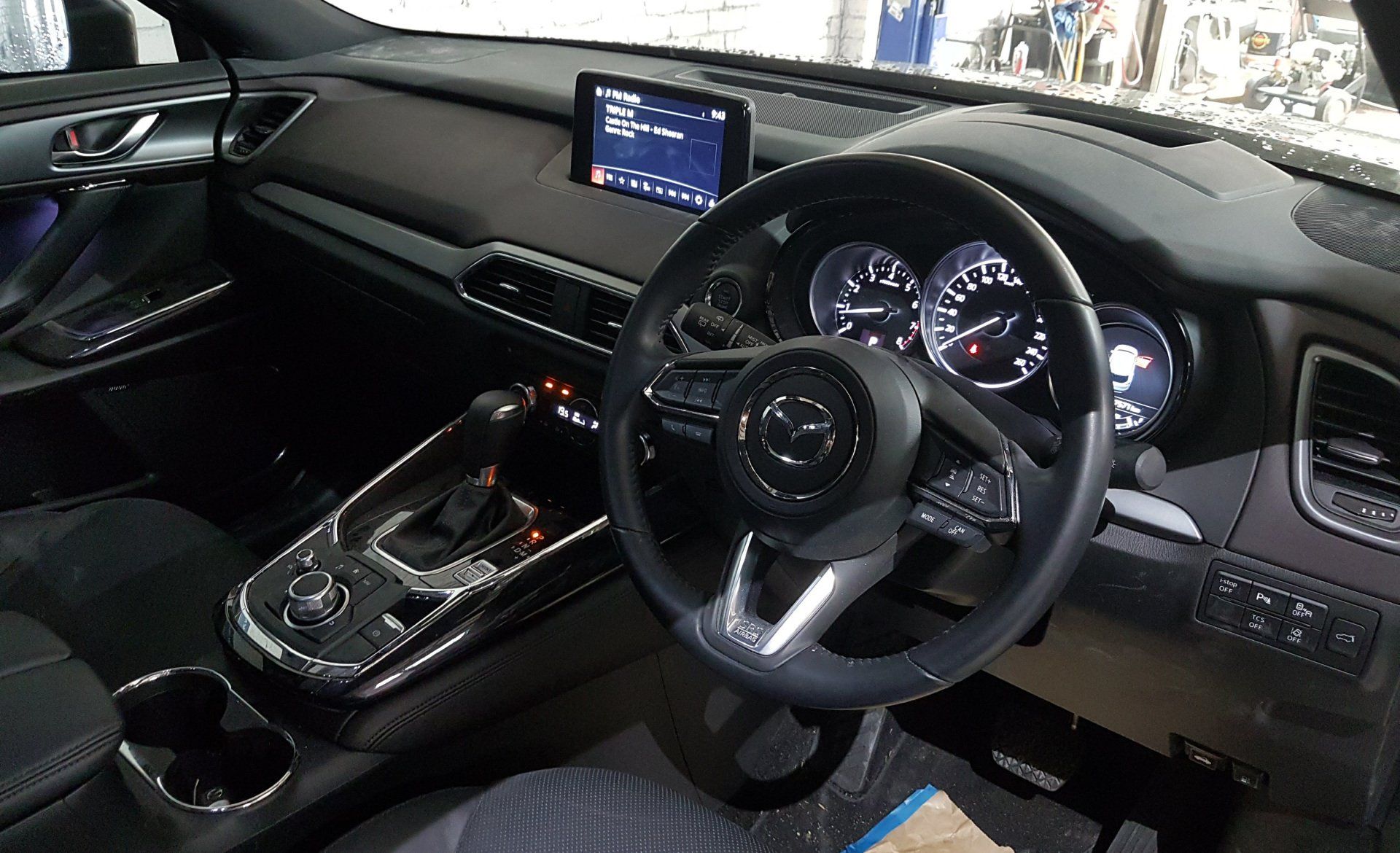 The interior of a car with a steering wheel and dashboard.