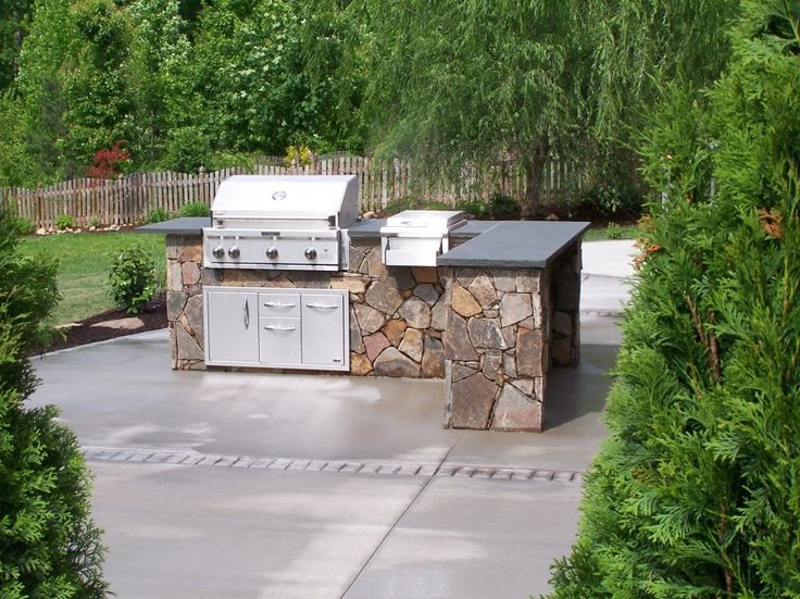 Modern outdoor kitchen in Maryland featuring grill island and paver patio