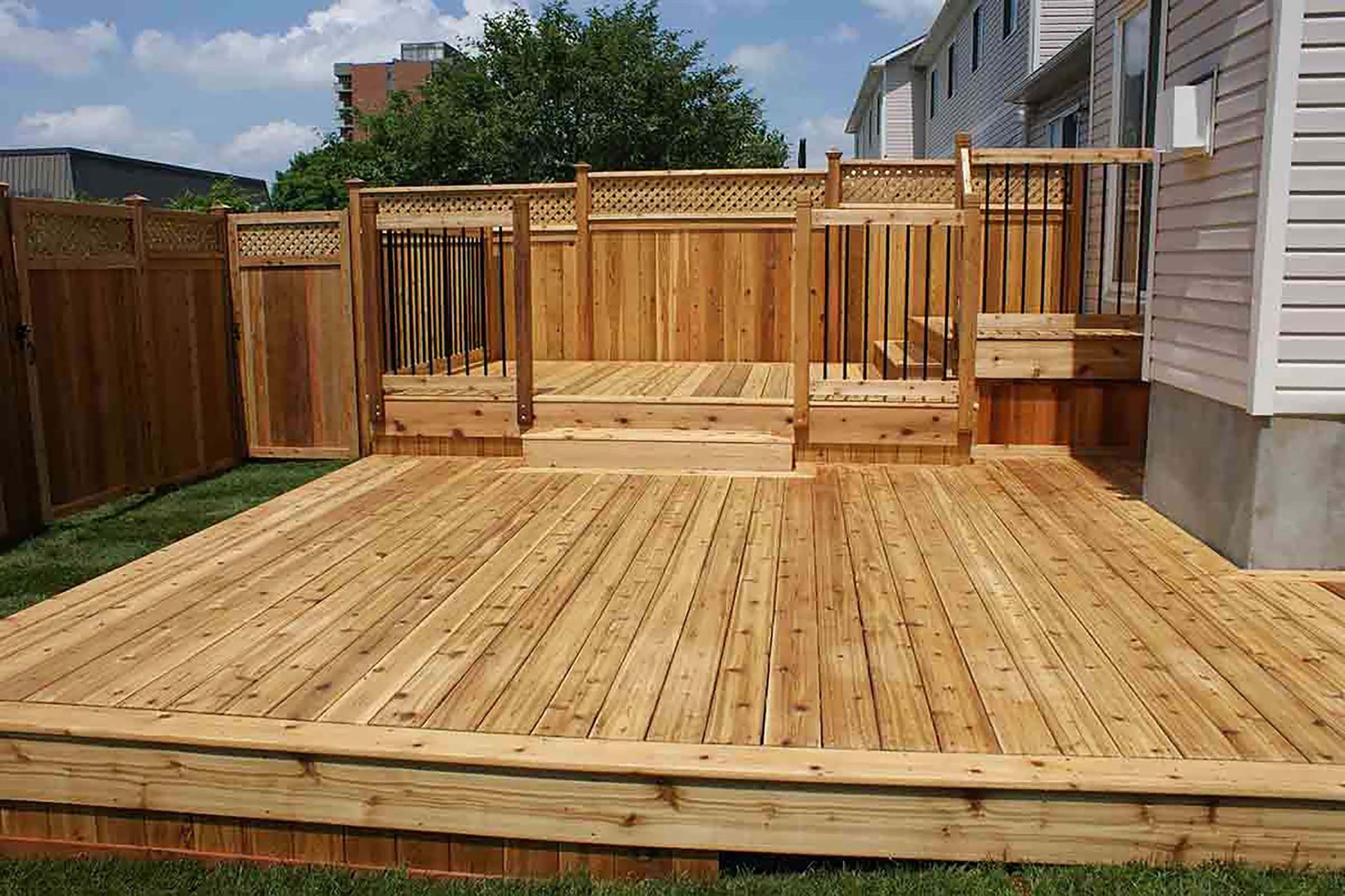 Multi-level treated wood deck perfect for outdoor hosting and enjoyment | J Gonzalez