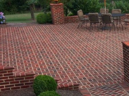 A brick patio with a table and chairs on it