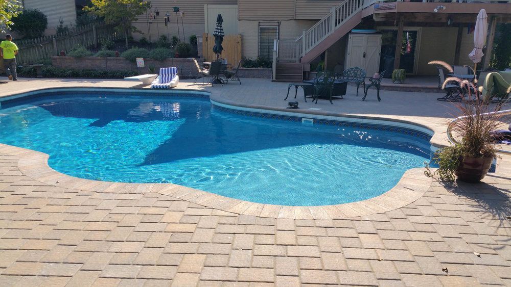 Custom inground pool with stone paver pool deck installed by J Gonzalez Construction in Maryland, designed for functional outdoor living and relaxation.