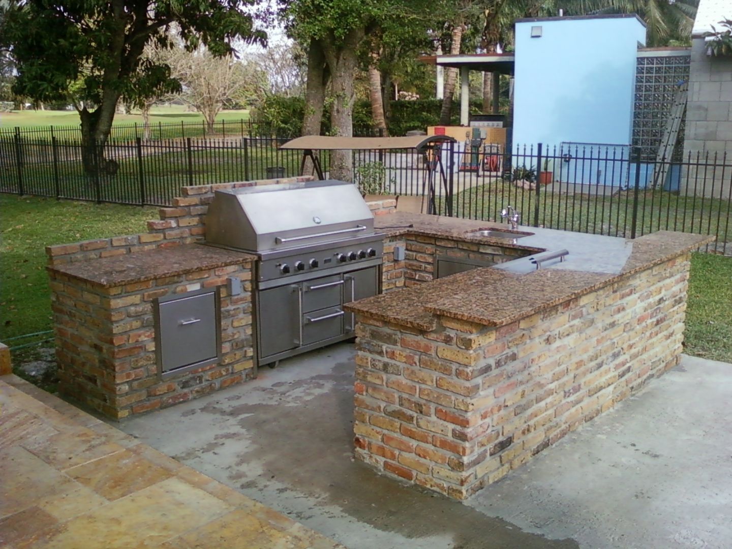 Custom outdoor kitchen with stone countertops, built-in grill, and sink | J Gonzalez Construction