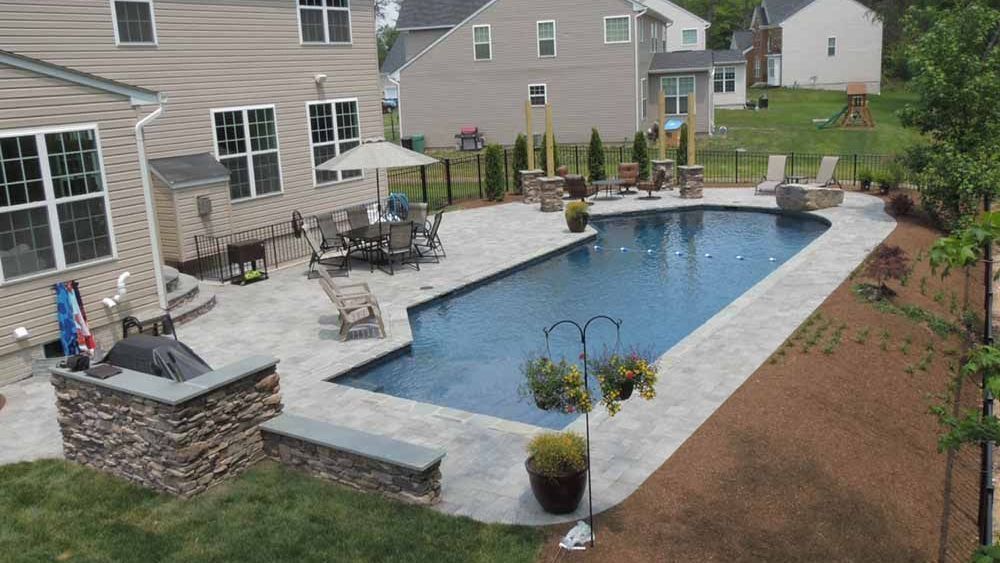 Backyard with pool, hardscaping patio, and landscaped garden design in Maryland”