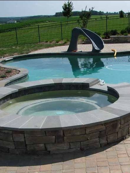 A large swimming pool with a slide and a hot tub in maryland