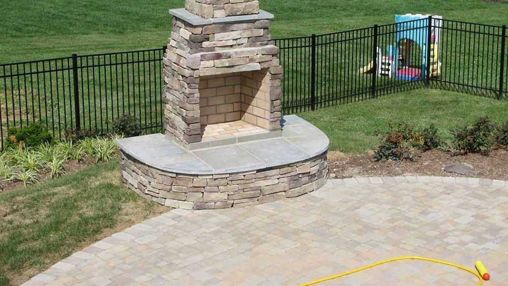 Natural stone patio with custom outdoor fireplace installed by J Gonzalez in Maryland