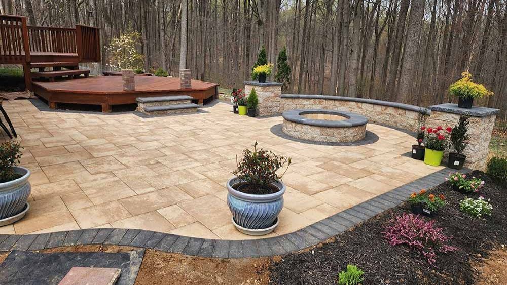 Outdoor living space in Maryland with deck, paver patio, retaining wall and fire pit