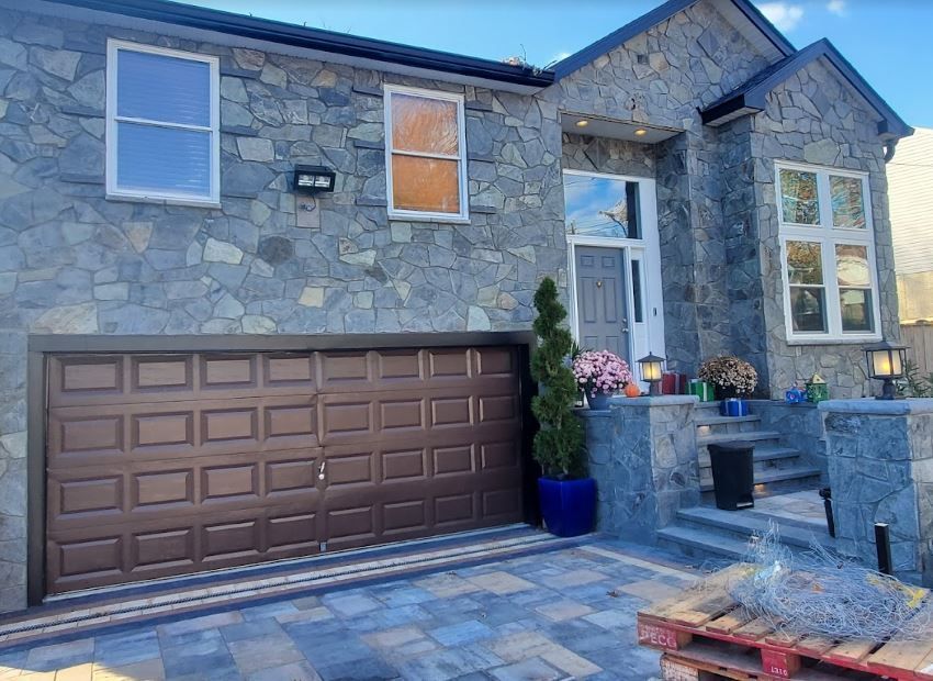 A large stone house with a brown garage door