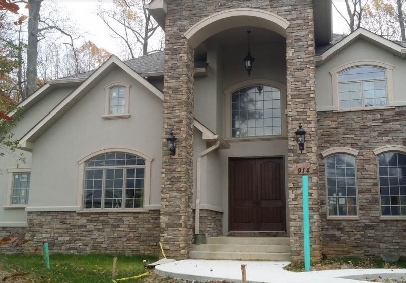 A large house with a stone pillar in front of it