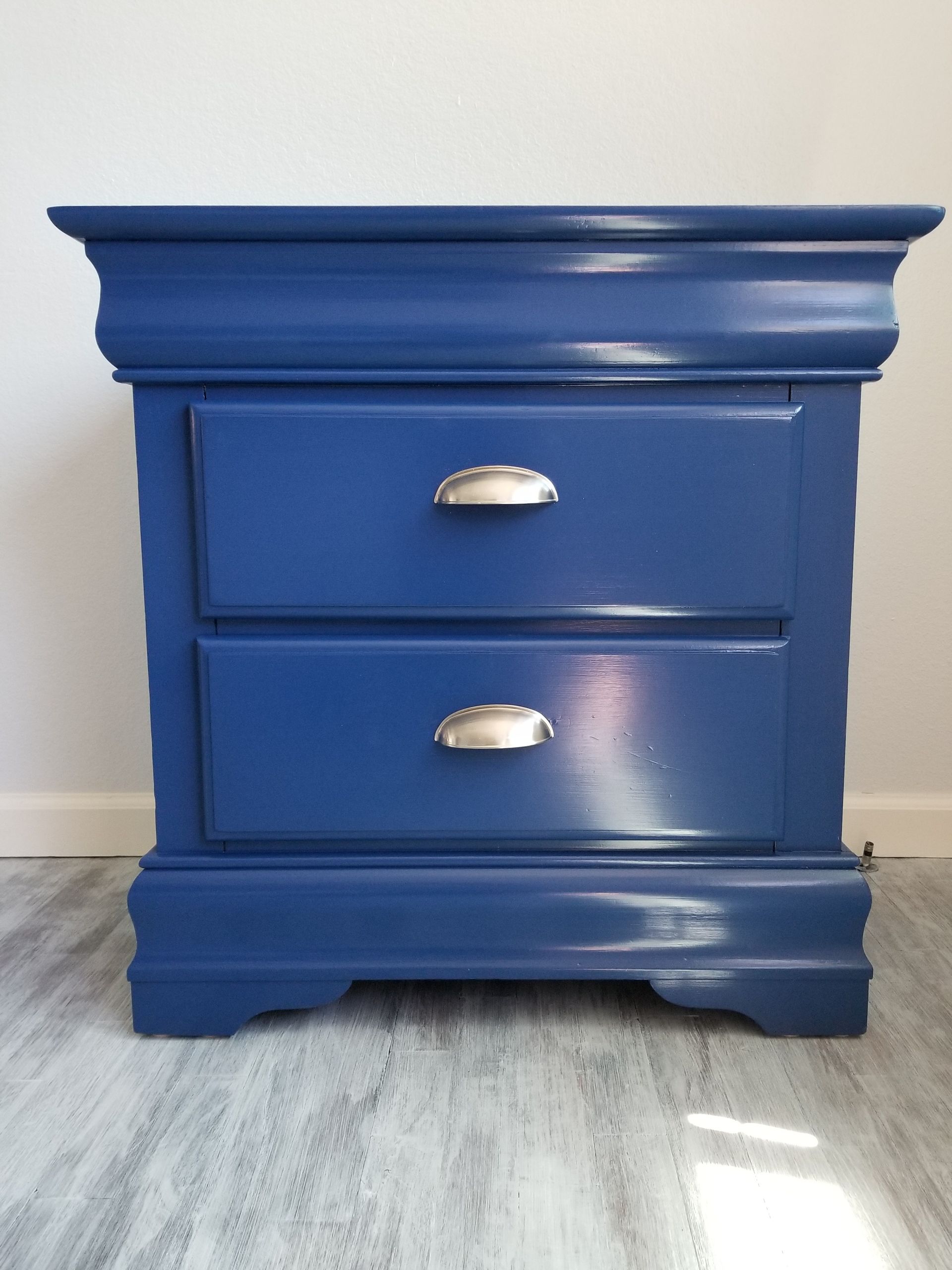 A blue nightstand with two drawers and silver handles