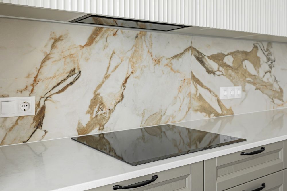 A kitchen with a marble backsplash and a stove top oven.