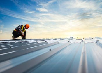 A man is working on the roof of a building.