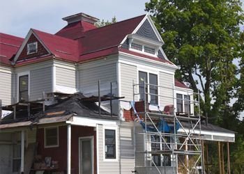 A house with a red roof is being remodeled.