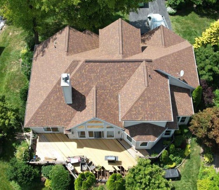 An aerial view of a large house with a brown roof