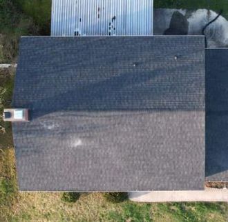 An aerial view of a house with a roof and a chimney.