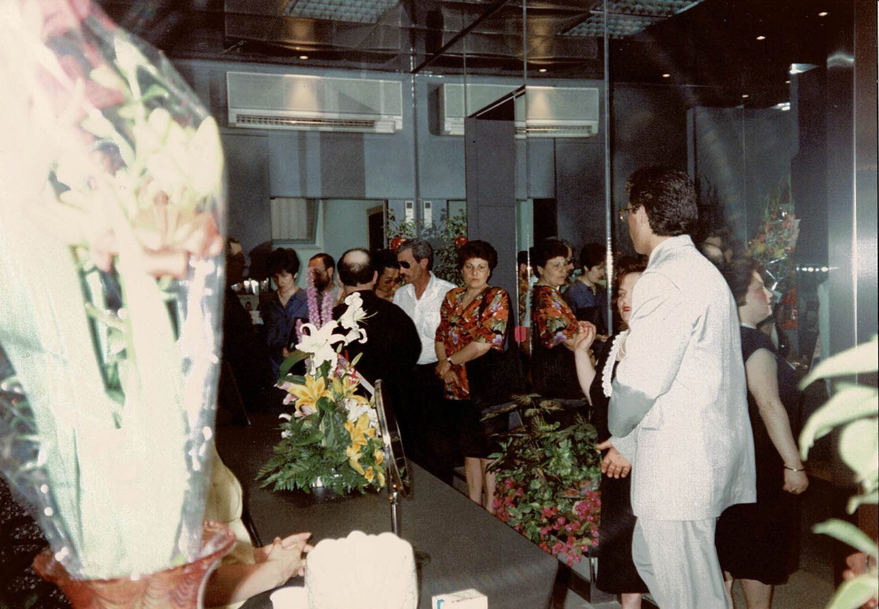 Un gruppo di persone in piedi attorno a un tavolo con dei fiori