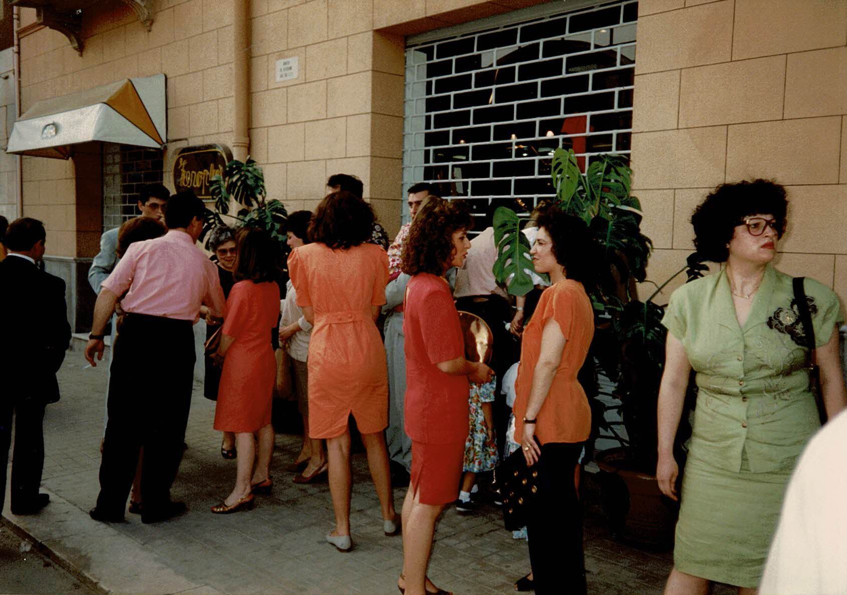Un gruppo di persone in piedi fuori da un edificio con un cartello che dice