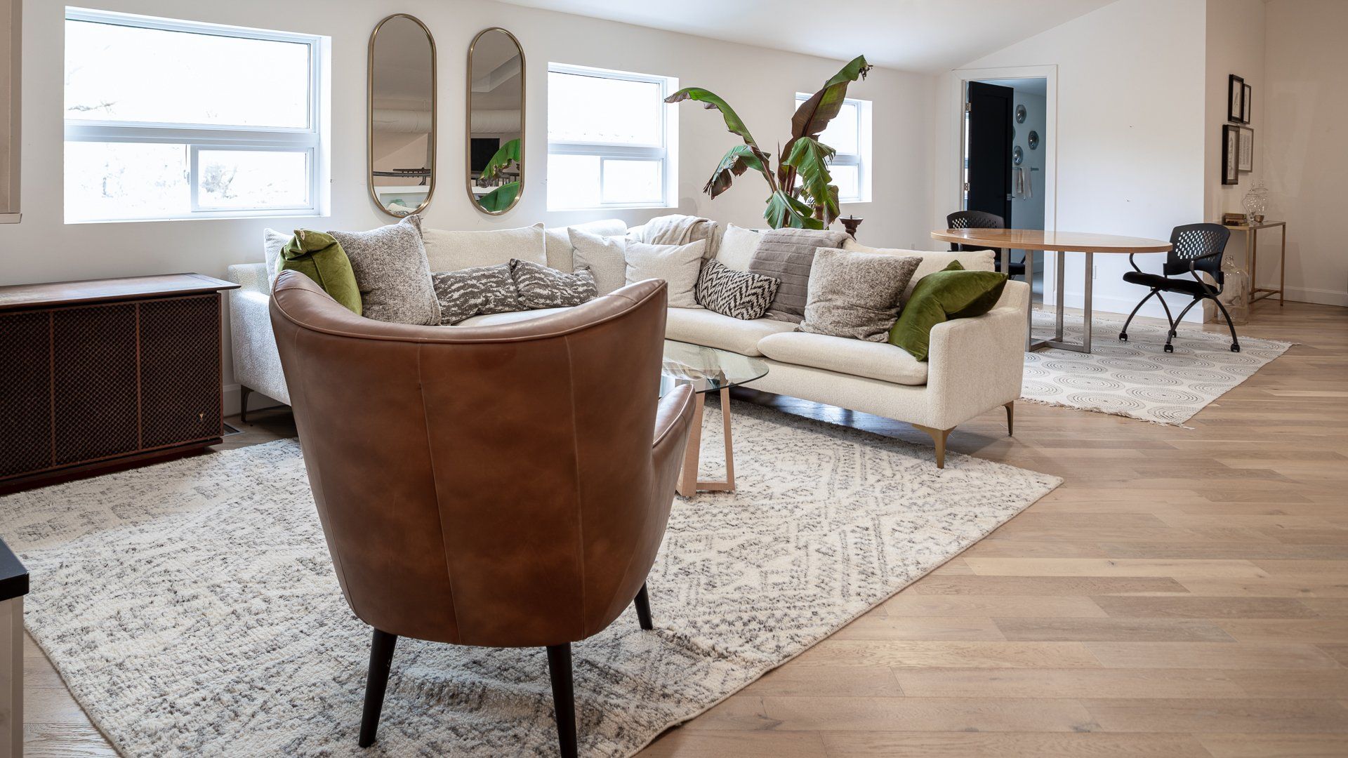 a living room with a couch , chairs , and a rug .