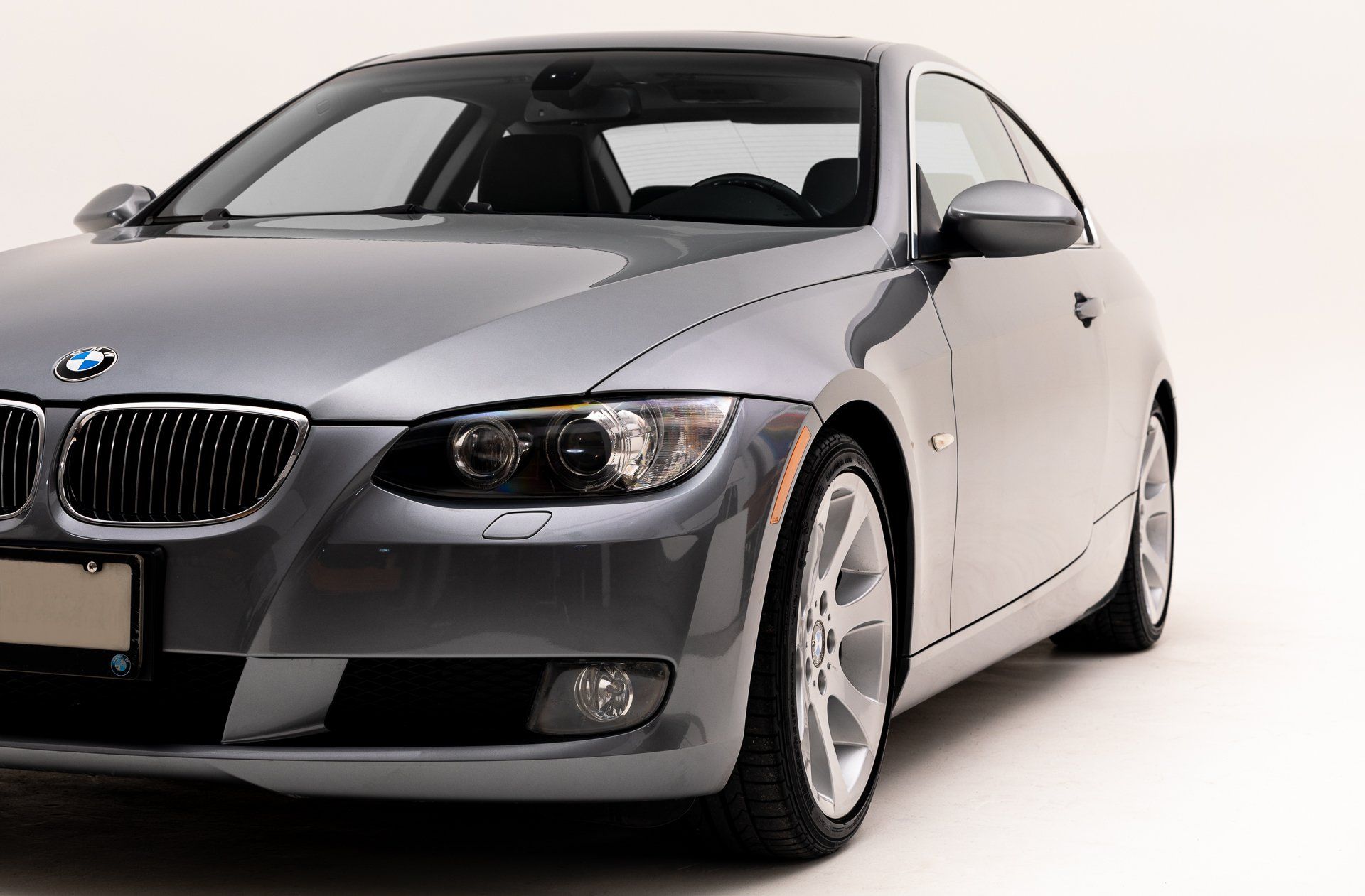 a gray bmw is parked on a white background