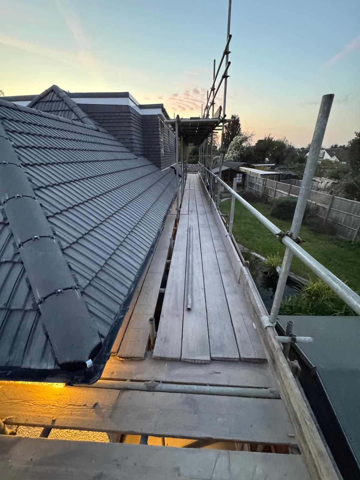 Close-up of gray corrugated metal roofing, with curved ridges and openings.