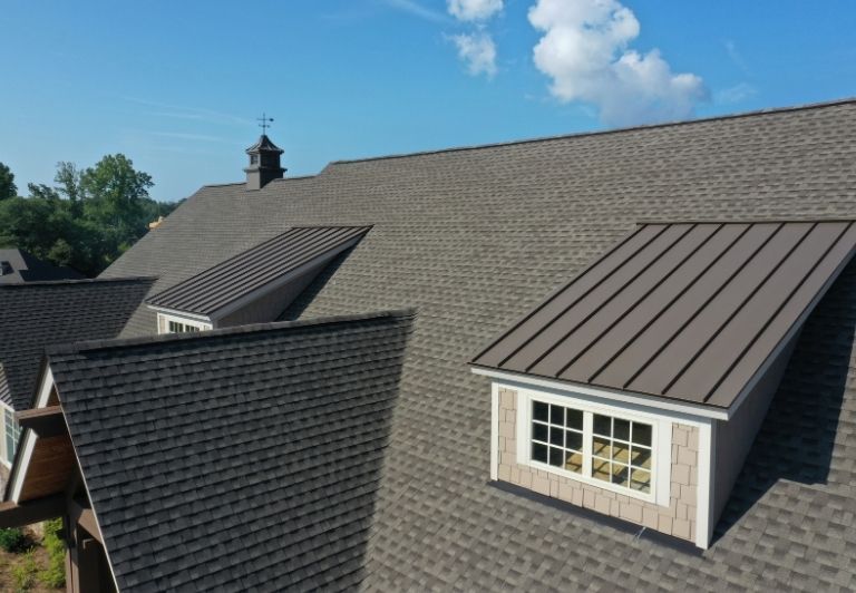 Close-up view of a shingled roof with a grey and black speckled pattern.