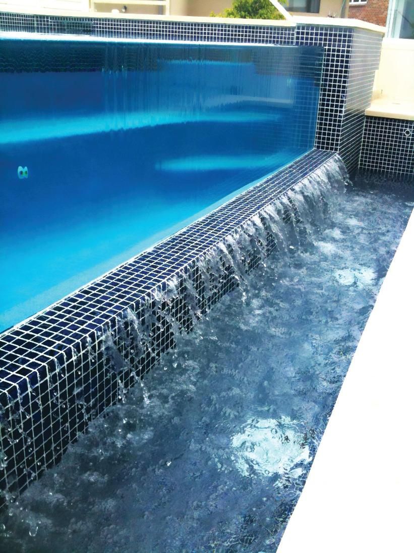 A Swimming Pool With A Waterfall In The Middle Of It — Glass Pool Windows Australia In Old Bar, NSW