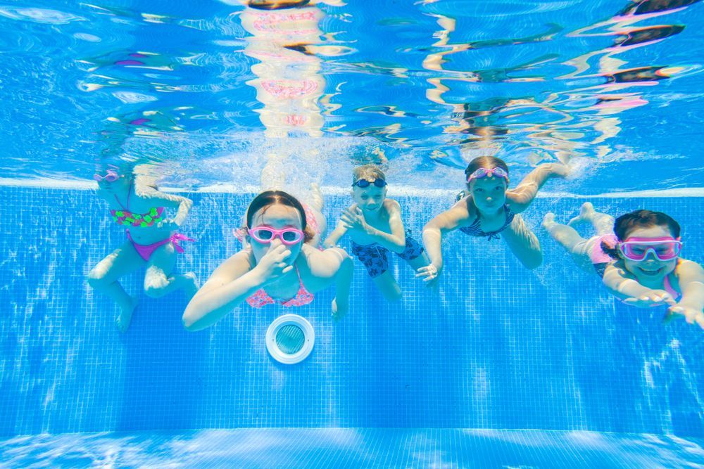 A Group Of Children Are Swimming Underwater In A Swimming Pool — Glass Pool Windows Australia In Old Bar, NSW
