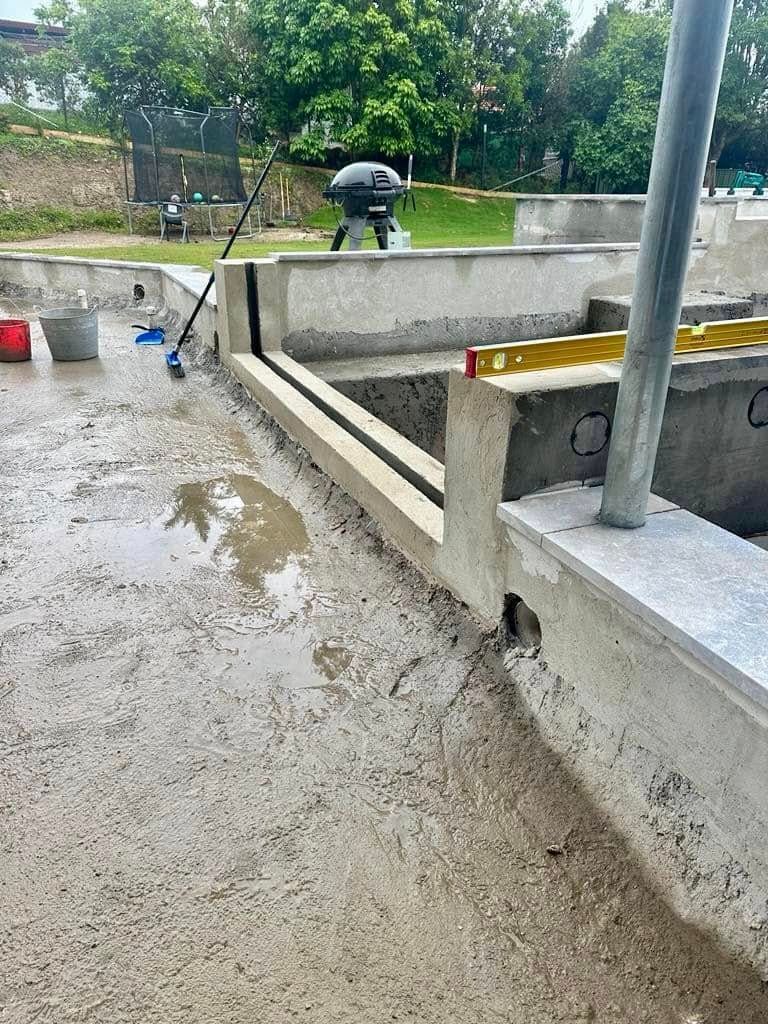 A Concrete Wall Is Being Built Next To A Pool — Glass Pool Windows Australia In Newcastle, NSW