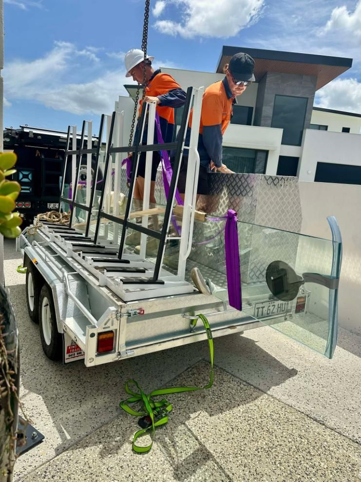 Two Men Are Working On A Trailer Filled With Glass — Glass Pool Windows Australia In Tweed Heads, NSW