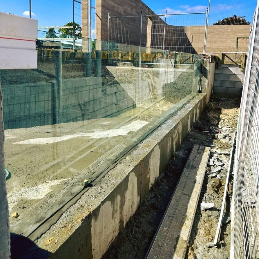 A Construction Site With A Fence And A Concrete Wall — Glass Pool Windows Australia In Rockhampton, QLD