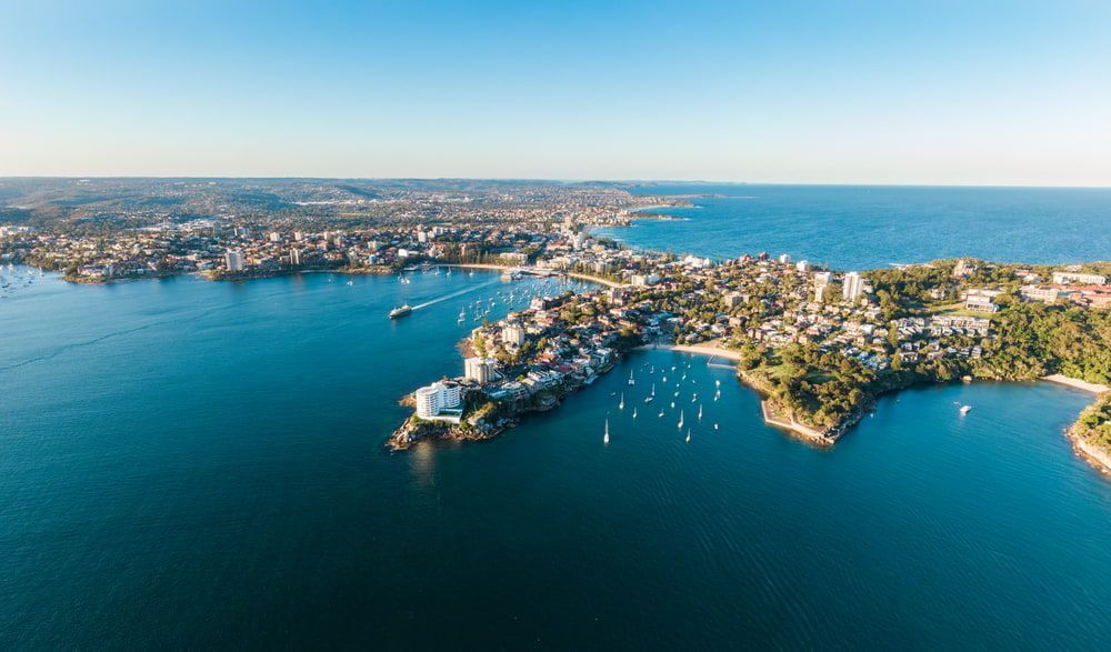 A Coastal Cityscape With a Calm Blue Sea — Glass Pool Windows Australia In Manly, NSW