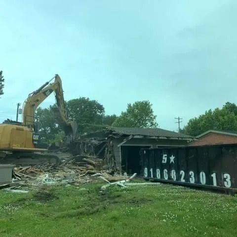 Bulldozer Demolishing a House Next to a Dumpster — Oktaha, OK — Five Star Roll-Offs Services