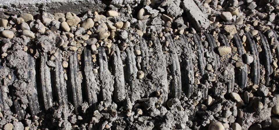 black tubing covered in beige gravel and rocks