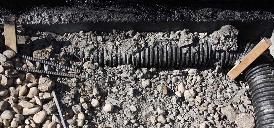 home infrastrucure with black tubing covered in rocks and gravel