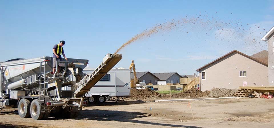 large truck pouring dirt for landscaping job