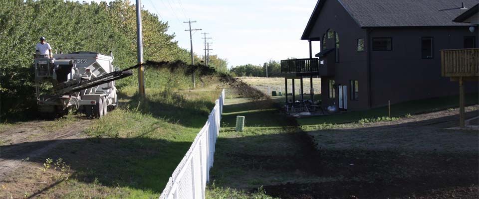 dirt being poured in backyard in preparation for grass installation