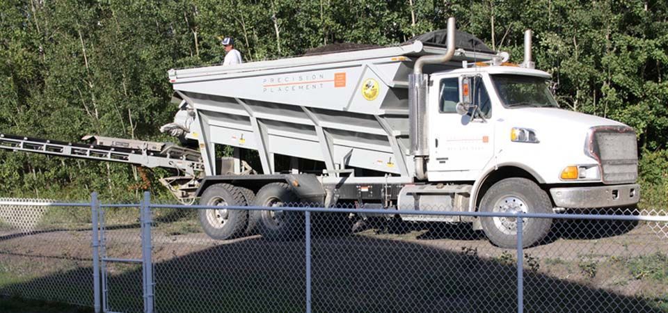 large white and grey dirt truck with conveyer belt