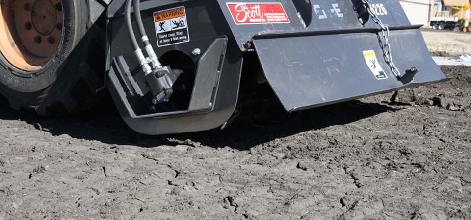 dark brown dirt being flattened by heavy machinery
