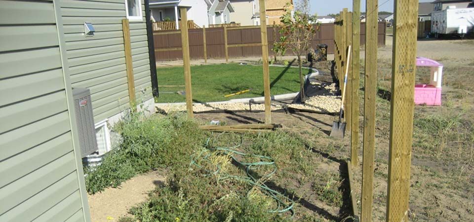backyard with swingset and pebble landscaping