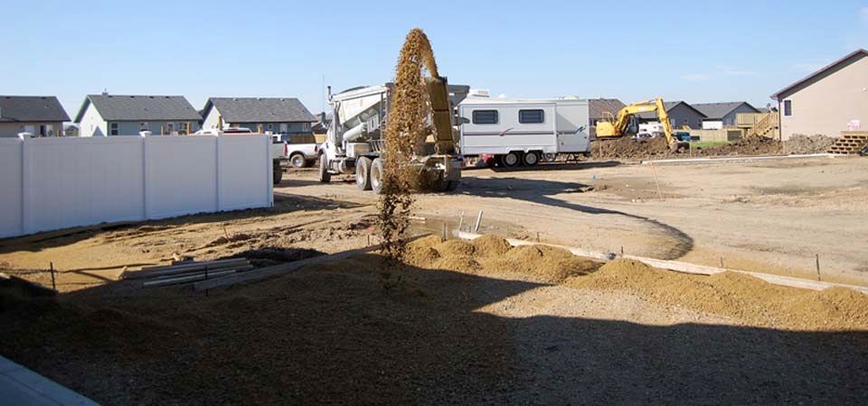 truck pouring dirt in backyard in preparation for landscaping job