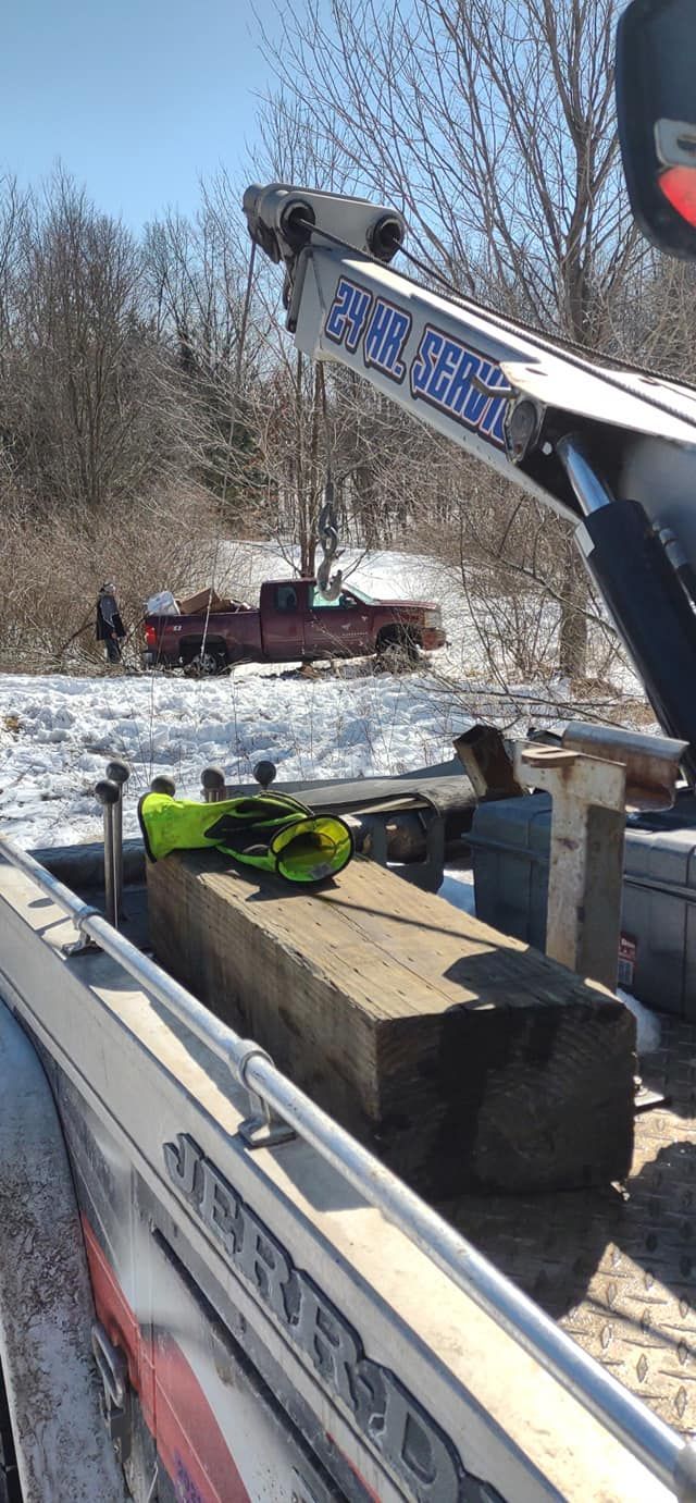 a boat is being towed by a tow truck in the snow .