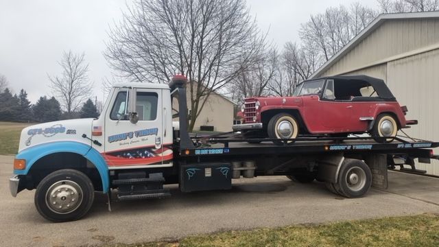 a tow truck with a red car on the back of it
