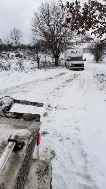 a fedex truck is driving down a snowy road