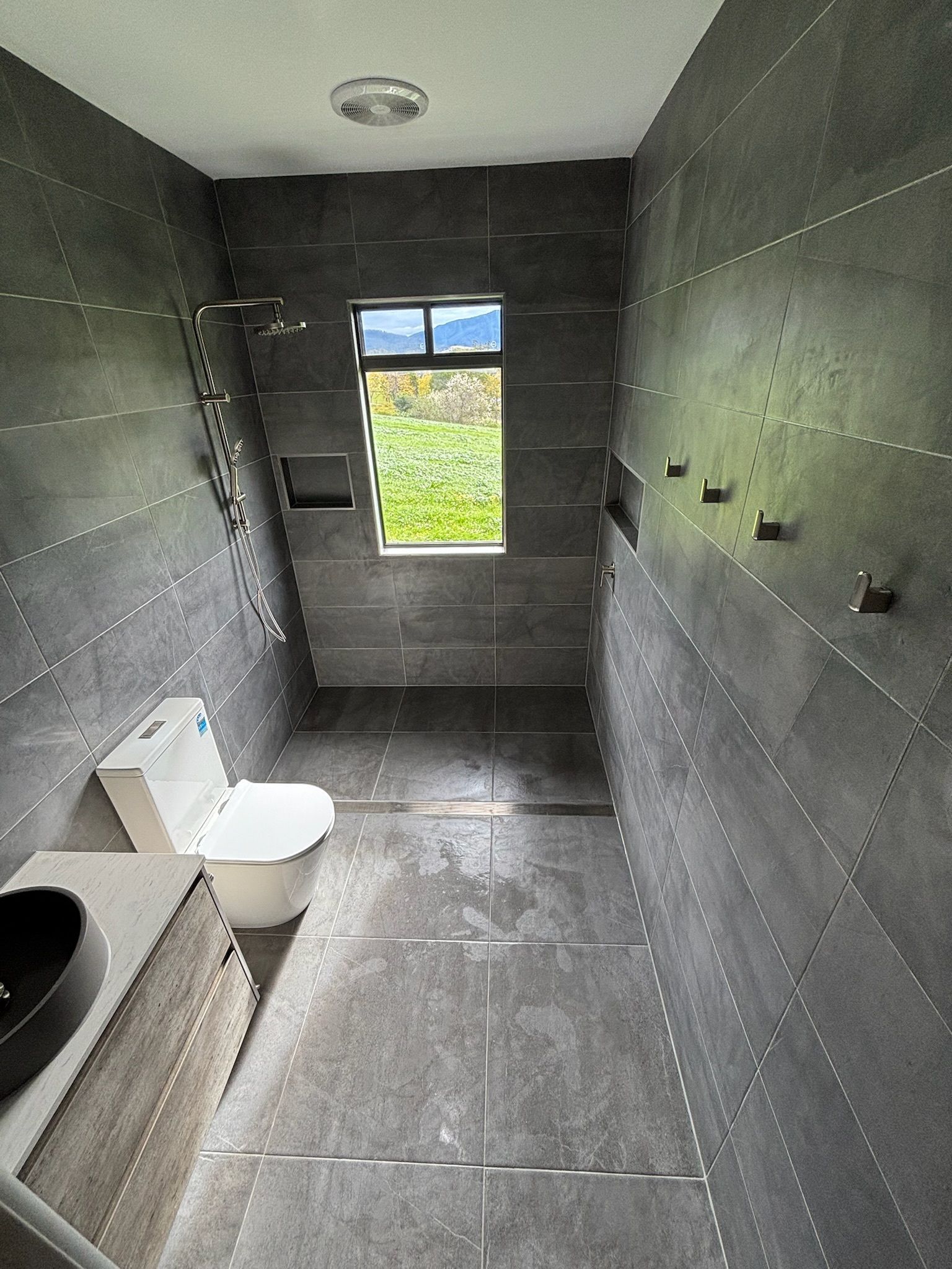 A Modern Bathroom With Gray Tiled Walls and Floor — Edmonds Bathroom Renovations & Tiling In Laurieton, NSW