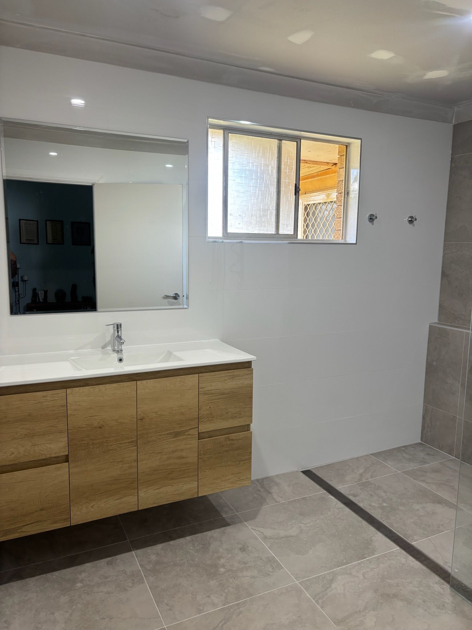Modern Bathroom With Light Gray Walls and Wooden Vanity — Edmonds Bathroom Renovations & Tiling In Port Macquarie, NSW