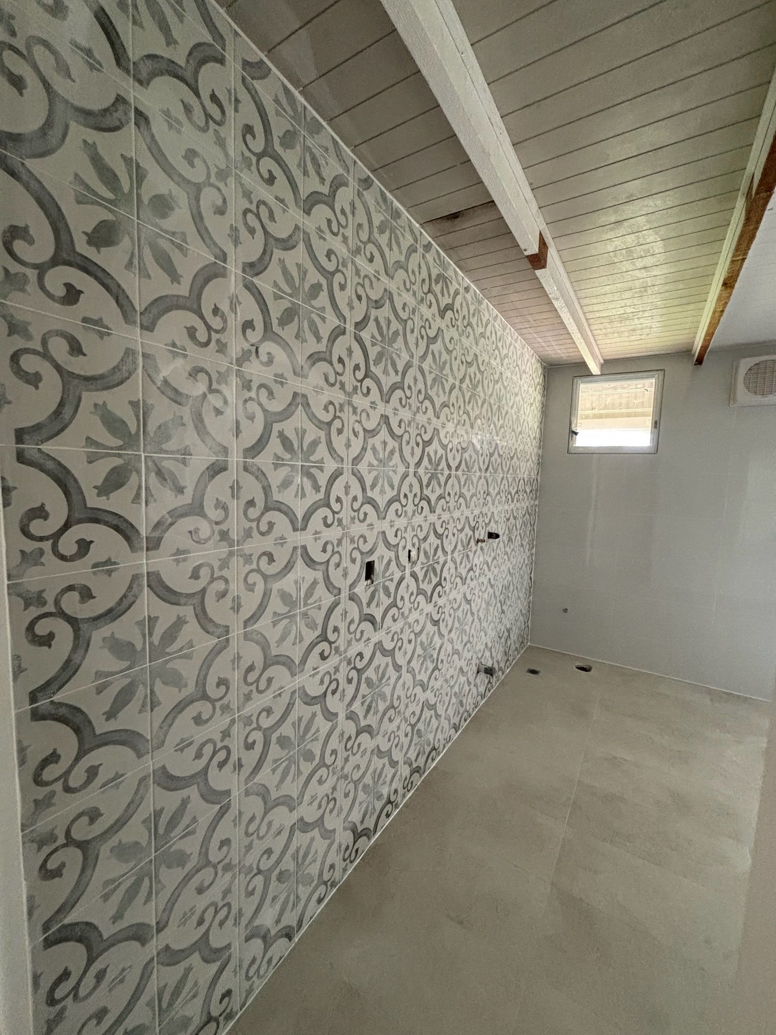 Tiled Accent Wall With Ornate Grey and White Pattern in a Room — Edmonds Bathroom Renovations & Tiling In Lake Cathie, NSW