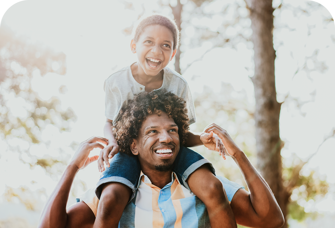 A father giving his son a shoulder ride.