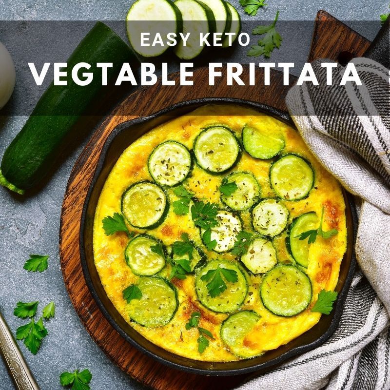 Easy keto vegetable frittata in a skillet, topped with zucchini slices and parsley.