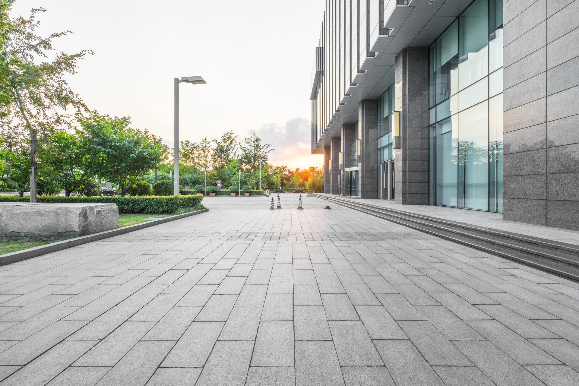 An empty sidewalk in front of a large building.