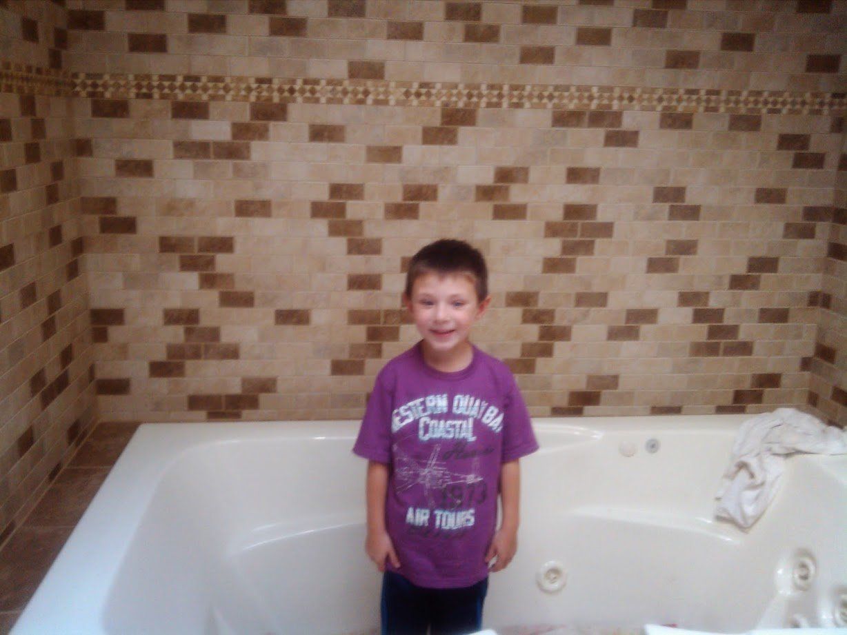 Child Standing in a Bathtub — Marlborough MA  — Bob Dolan Plumbing, Heating & Remodeling