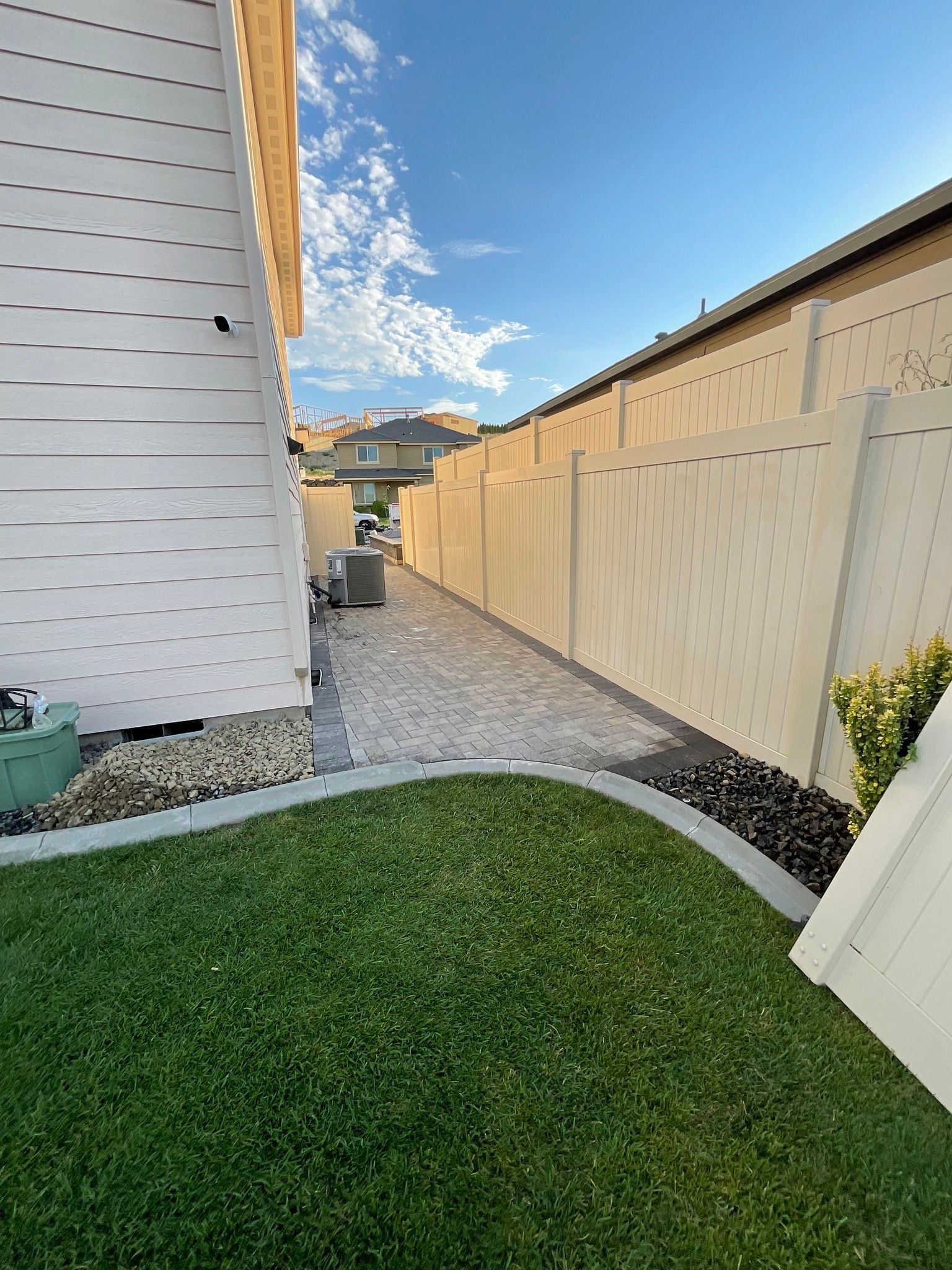 A house with a fence and a lawn in front of it.